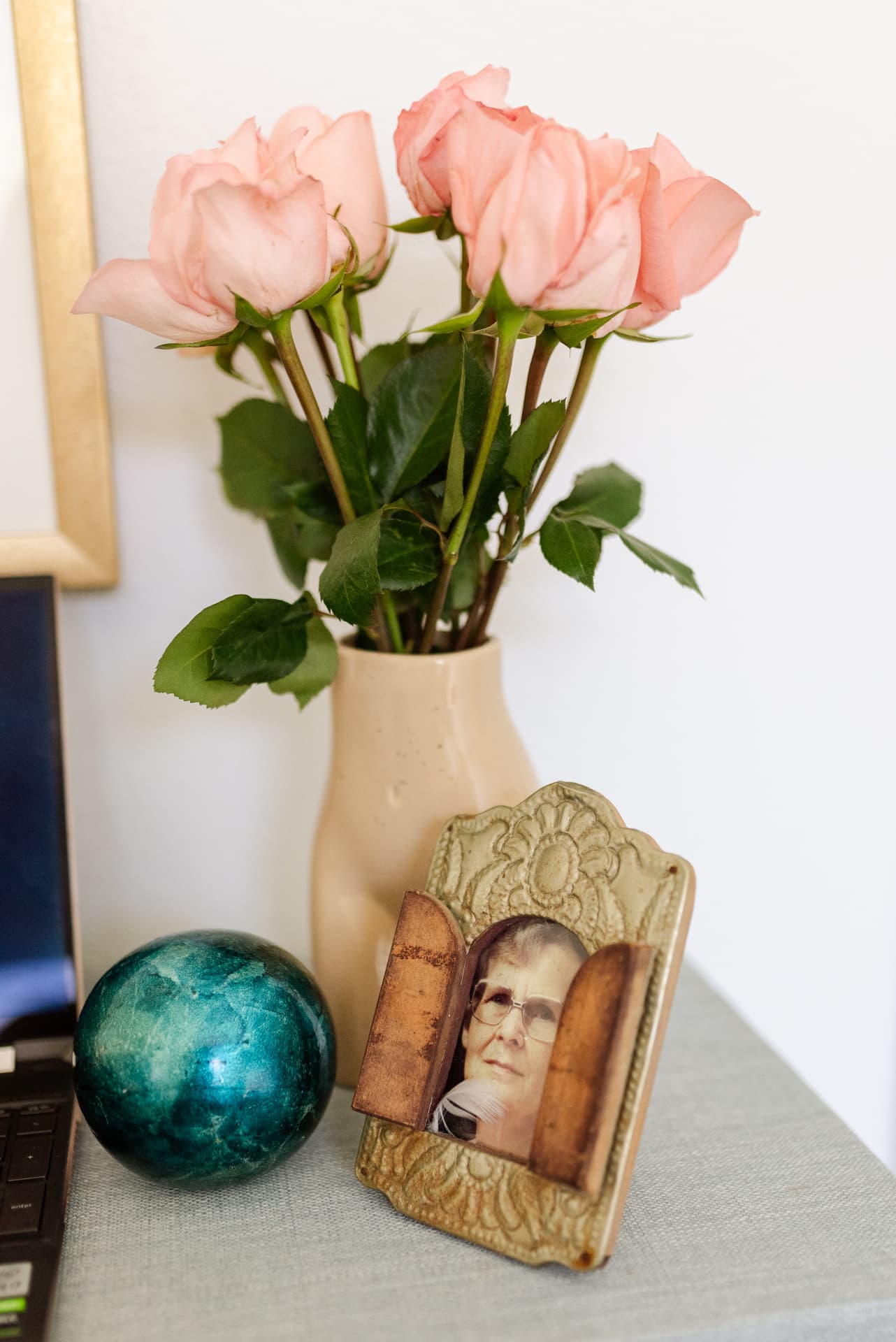 Pink roses beside a framed portrait of Hildegard on Nina's desk